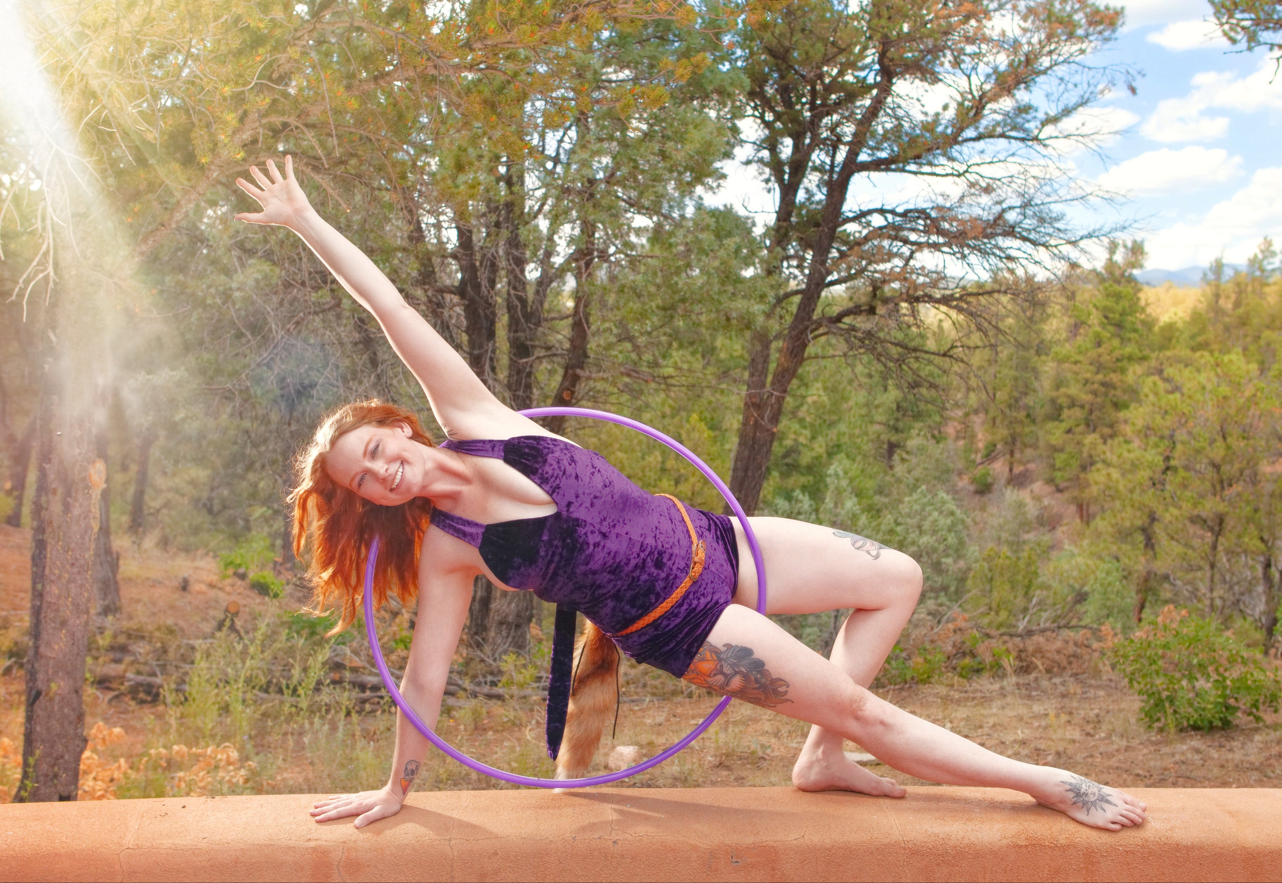 Person performing with a hula hoop in a forest setting