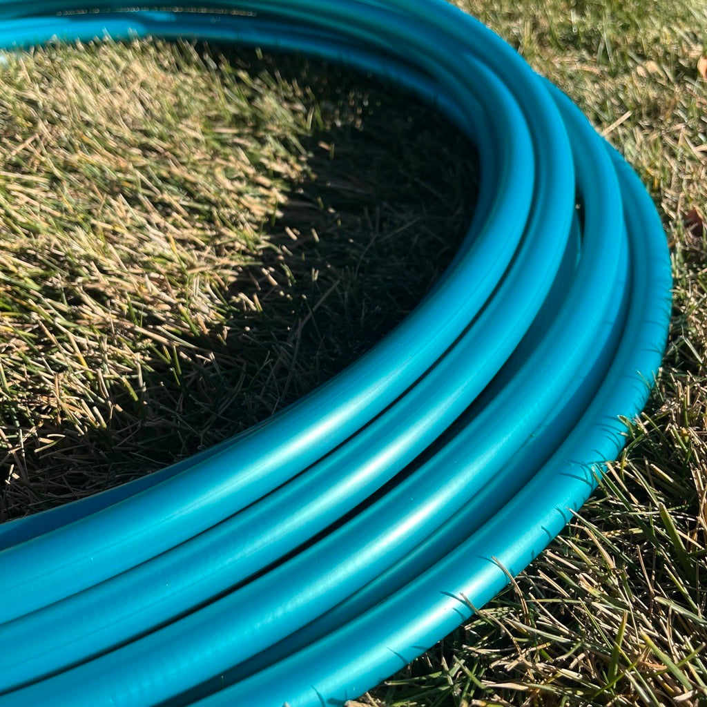 Pearlescent teal polypro hoop in bright natural light.